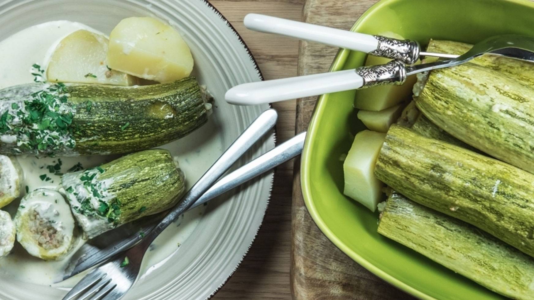 Γεμιστά κολοκυθάκια με πατάτες σε κρεμώδη σάλτσα, σερβιρισμένα σε πιάτο και μπολ.