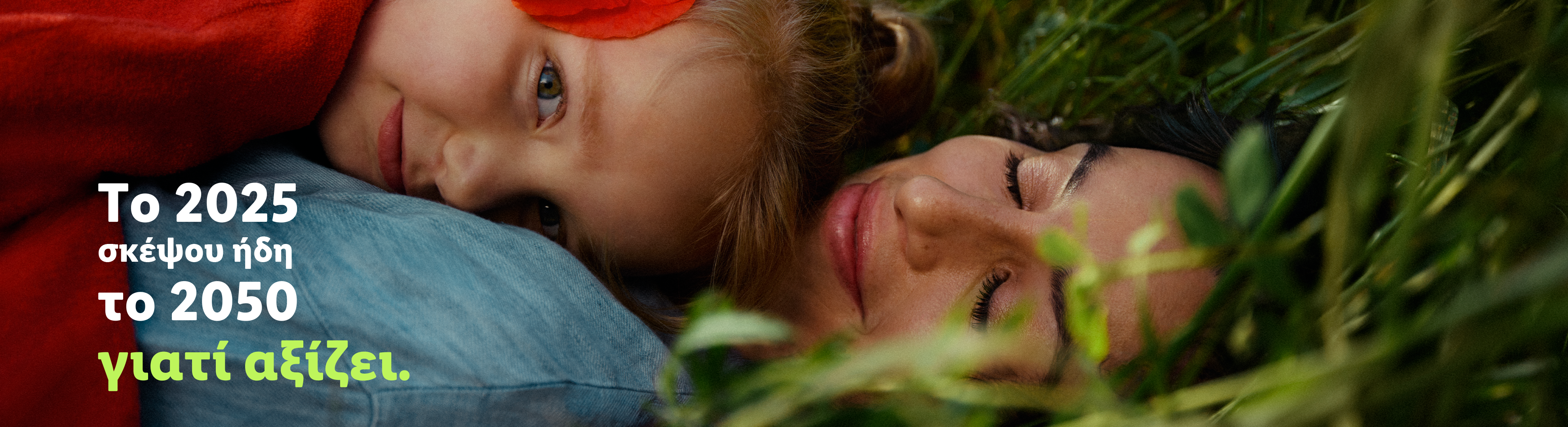 Μια γυναίκα και ένα παιδί ξαπλωμένοι στο γρασίδι, με κείμενο που λέει: «Το 2025 σκέψου ήδη το 2050 γιατί αξίζει».