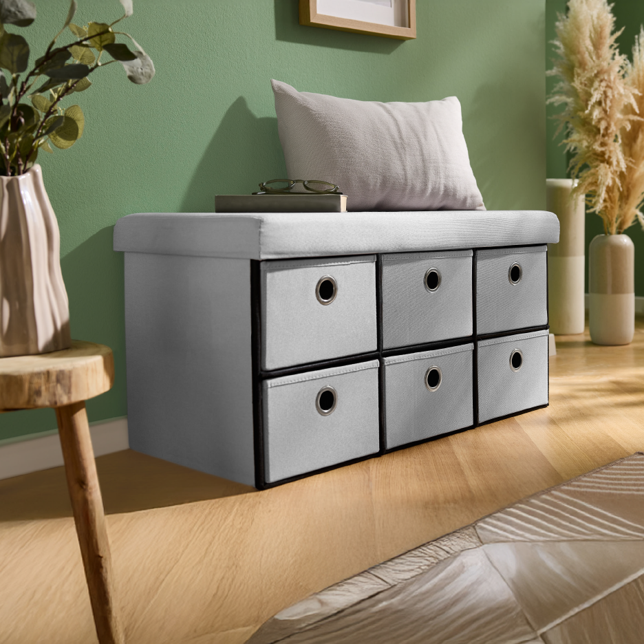 Πάγκος αποθήκευσης με έξι συρτάρια, διακοσμημένος με μαξιλάρι και φυτά.