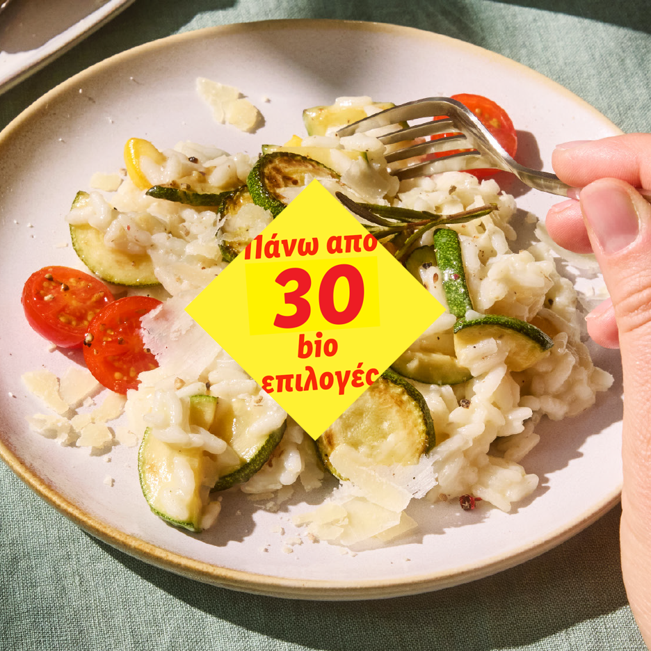 Ριζότο με κολοκυθάκια, ντοματίνια και παρμεζάνα. Κείμενο: «Πάνω από 30 βιο επιλογές».