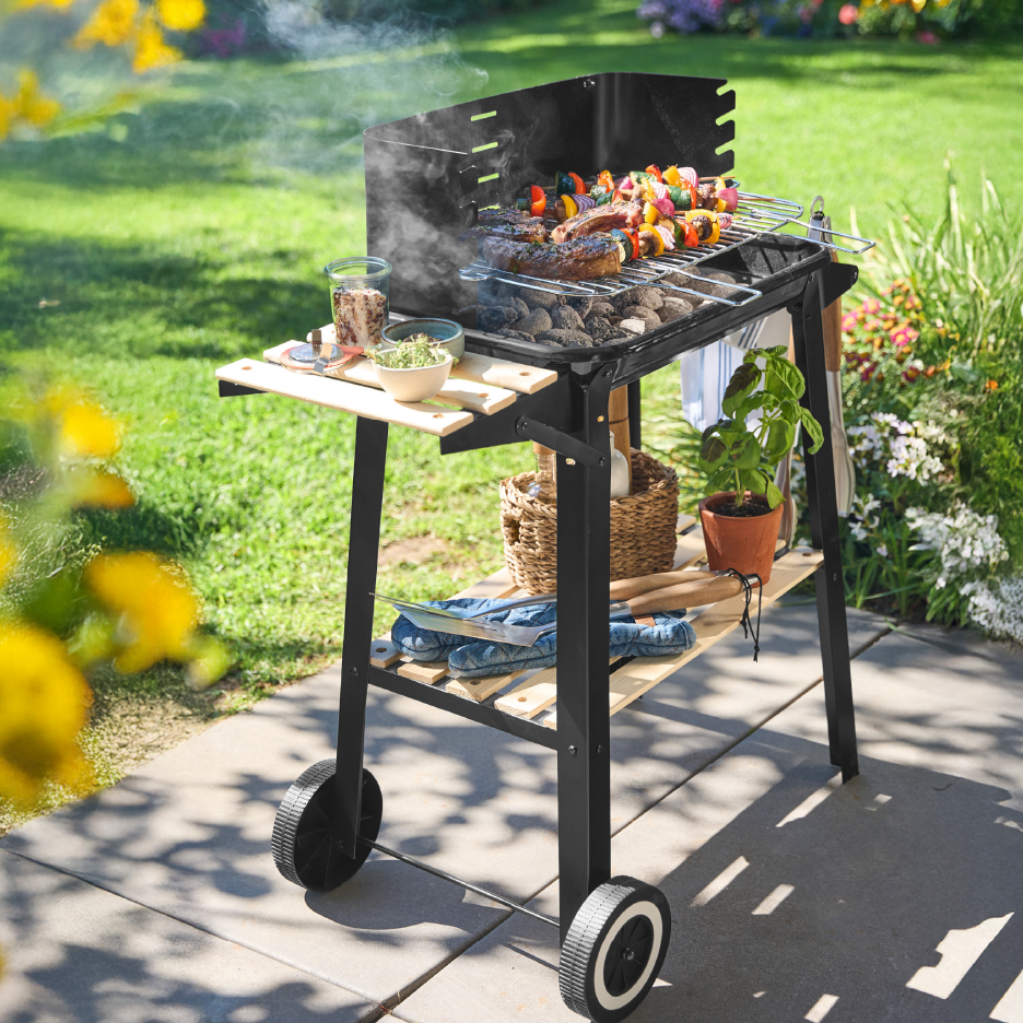 Μπάρμπεκιου με κάρβουνα, κρέας και σουβλάκια λαχανικών σε εξωτερικό χώρο.