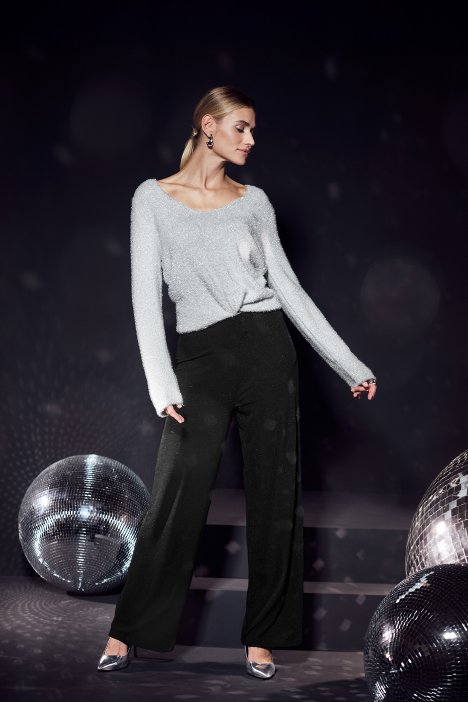 Γυναίκα με γκρι πουλόβερ και μαύρο παντελόνι