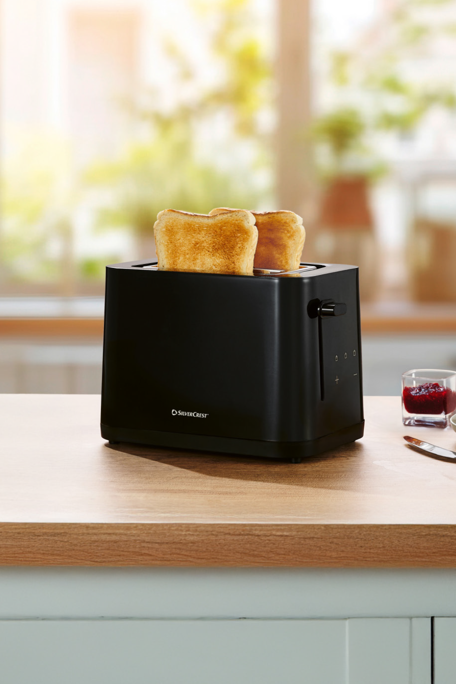 Μαύρη φρυγανιέρα Silvercrest με φρυγανισμένο ψωμί σε ξύλινο πάγκο κουζίνας.