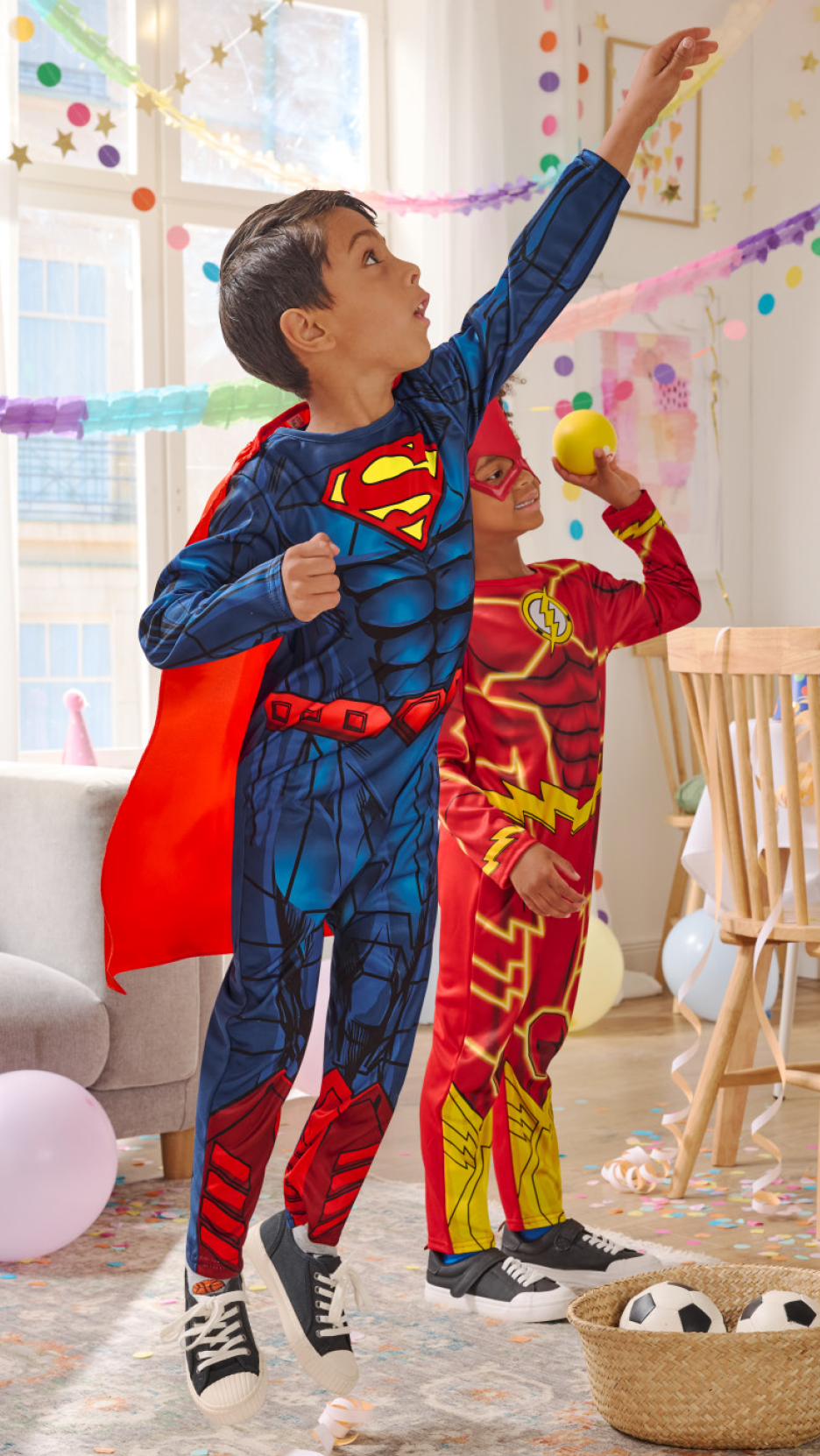 Παιδιά ντυμένα με στολές υπερηρώων, ο ένας ως Σούπερμαν και ο άλλος ως Φλας, σε ένα πάρτι.