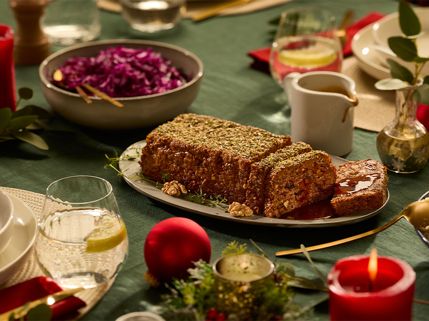 Χριστουγεννιάτικο τραπέζι με χορτοφαγικό ρολό, κόκκινο λάχανο και διακόσμηση.