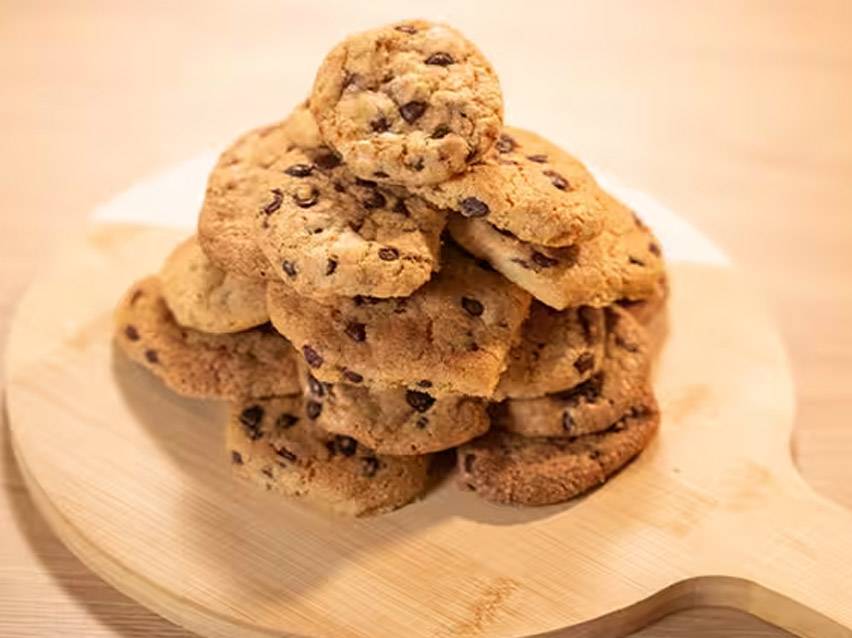 Στοίβα από μπισκότα σοκολάτας σε ξύλινη επιφάνεια κοπής.