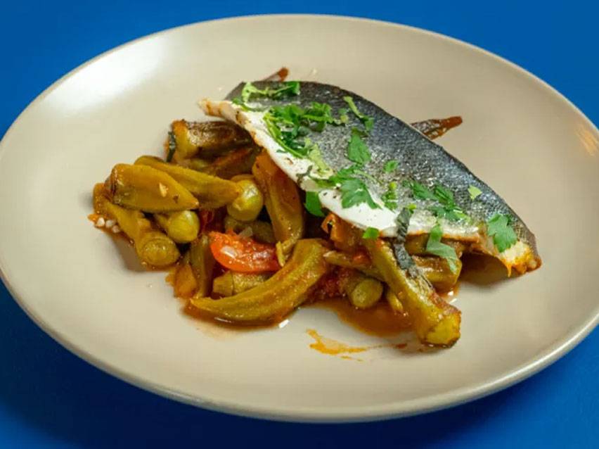 Ψάρι με μπάμιες και ντομάτες σε πιάτο