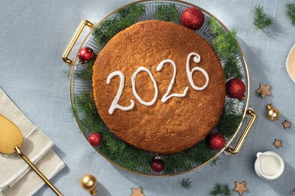 Χριστουγεννιάτικο κέικ με τον αριθμό 2026, διακοσμημένο με γκι και κόκκινες μπάλες.